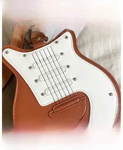 Détail du sac bandoulière en forme de guitare en cuir PU marron avec rivets métalliques