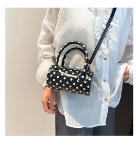 Borsa a tracolla cilindrica a pois con manici rotondi indossata dalla modella