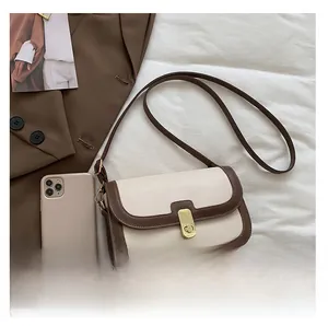 Gros plan détaillé d'un sac à bandoulière crème et marron avec fermoir doré chic