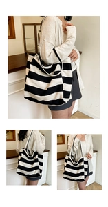 Detail of a large striped canvas tote bag with black shoulder straps for daily use