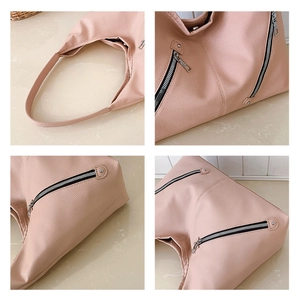 Detailed close-up of light pink pebble leather hobo bag with silver zipper hardware