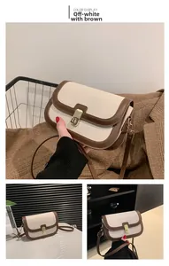 Détail d'un sac bandoulière en cuir crème et marron avec boucle en métal doré