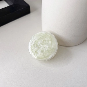 Macro view of light green pearlescent glitter phone socket grip on white desk