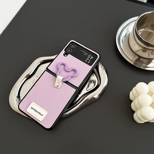 Detailed texture of purple leather case with Mickey-shaped metal ring for folding phone