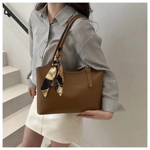 Caramel tote bag detail with vintage printed scarf wrapped on the handle in casual setting