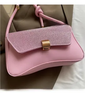 Close-up of pink leather baguette bag with shimmering sequin flap and gold metal buckle