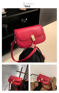 Détail d'un sac porté épaule en cuir rouge avec fermoir doré et coutures fines