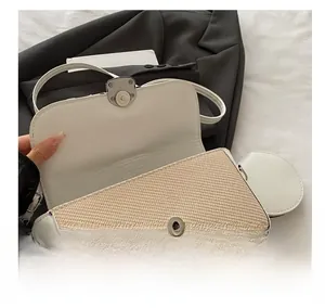 Detail of woven fabric handbag featuring a metallic magnetic buckle and a mini coin purse