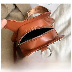 Détail du sac bandoulière marron en forme de guitare avec fermeture éclair argentée
