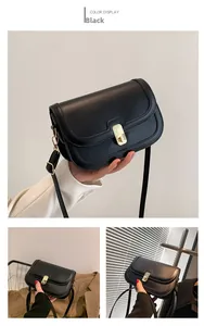 Détail d'un sac à bandoulière vintage en cuir noir avec un fermoir en métal doré chic