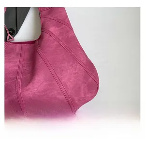 Detail of rose pink tote bag featuring diagonal stitched seams and matte leather texture