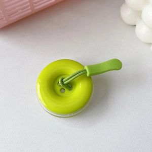 Dettaglio del supporto per telefono a forma di bottone verde con cinturino intrecciato