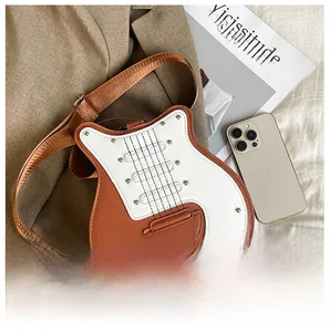 Détail d'un sac bandoulière en forme de guitare avec cordes cousues sur un blazer