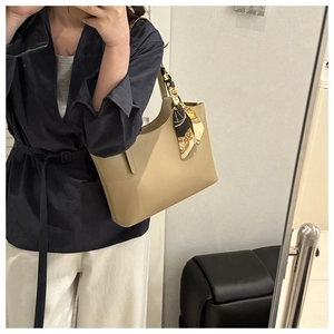 Chic beige tote bag with decorative silk scarf shown in a stylish commuter outfit context