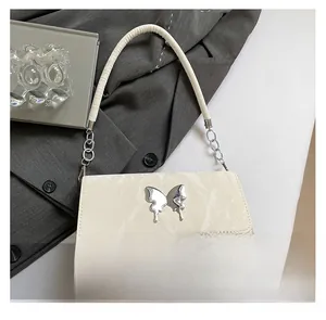 Macro detail of creamy white marble texture shoulder bag with silver butterfly metal buckle