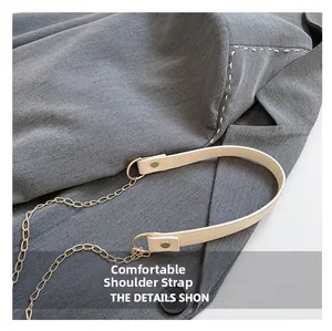Close-up of off-white lychee leather and gold metal chain strap on a designer handbag