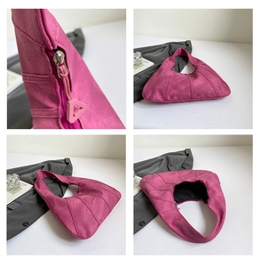 Detailed close-up of rose pink suede hobo bag features zipper and stitching texture