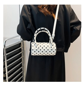 Borsa a baguette a pois indossata a spalla con tracolla regolabile e finitura lucida