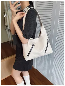 Detail of cream white leather hobo bag with stylish dual zippers and pebbled texture