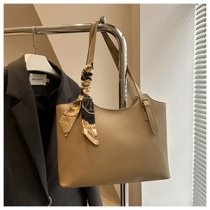 Detail of khaki tote bag with a decorative vintage ship pattern silk scarf on handle