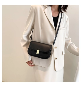 Sac bandoulière classique en cuir noir avec fermoir métallique doré sur un mannequin