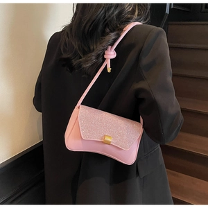 Pink baguette bag with sparkling glitter flap and gold buckle shown on a model