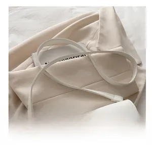 Détail du sac sous l'aisselle en cuir blanc avec fine bandoulière et boucle élégante