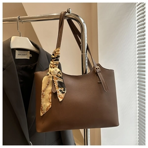 Detail of coffee brown tote bag with decorative printed silk scarf on the handle