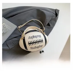 Detail of rugby-shaped crossbody bag featuring lychee grain leather and gold chain