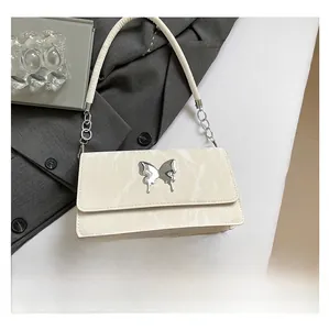 Detail view of butterfly buckle shoulder bag with size comparison to a smartphone