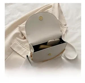 Vue intérieure du sac bandoulière blanc montrant l'espace pour mobile et portefeuille