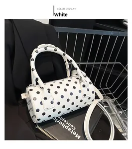 Dettaglio borsa baguette bianca a pois con doppi manici e tracolla lunga rimovibile