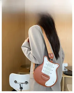 Détail du sac bandoulière en forme de guitare avec large sangle réglable sur un mannequin