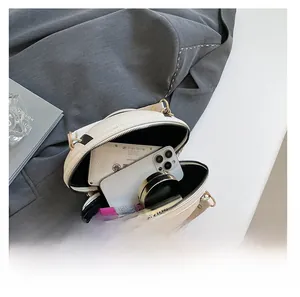 Macro shot of the off-white cylindrical crossbody bag showing its interior capacity storage