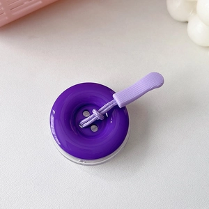 Dettaglio del supporto per telefono a bottone viola con cordino intrecciato e impugnatura