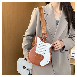 Détail d'un sac bandoulière créatif en forme de guitare avec une large sangle marron
