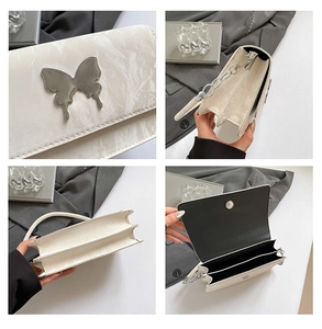 Detail of creamy white marble texture handbag with silver butterfly and chain strap