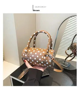 Elegante borsa marrone a pois bianchi mostrata in un riflesso specchiato raffinato