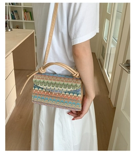 Detail of bohemian woven crossbody bag with colorful geometric patterns and knot handle