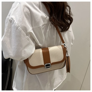 Chic beige woven crossbody square bag with brown leather trim shown on white shirt