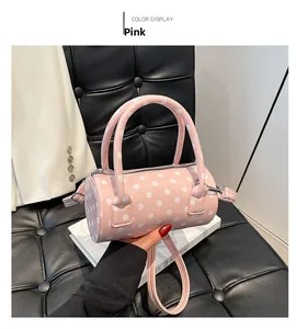 Borsa a cilindro rosa a pois bianchi con finitura lucida e tracolla regolabile