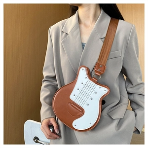 Détail du sac bandoulière en forme de guitare avec coutures contrastées et large sangle