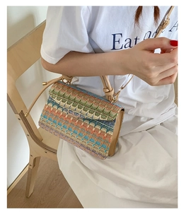 Detail of colorful geometric woven pattern and beige leather trim on stylish crossbody bag