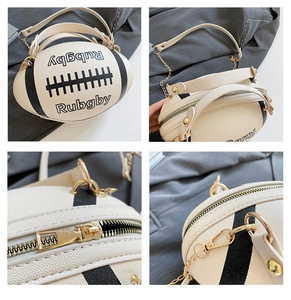 Detail view of rugby shaped crossbody bag with cream leather and gold hardware