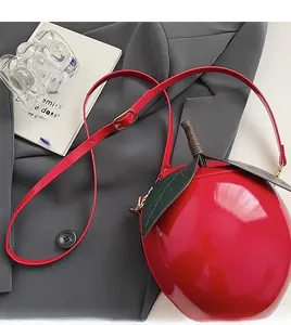 Détail macro du sac pastèque rouge avec feuille verte et finition vernie brillante