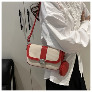 Detail of a chic cream woven crossbody bag with red leather trim and matching round coin purse