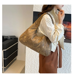 Detail of vintage brown leather hobo bag with unique pleated stitching and large capacity