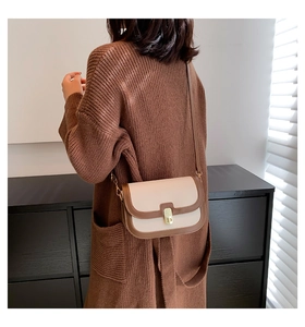 Détail du petit sac rétro bicolore avec fermoir métallique doré sur un gilet