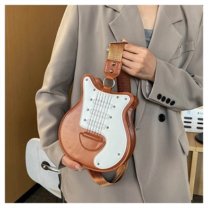 Détail du sac bandoulière en forme de guitare avec large sangle et détails contrastés