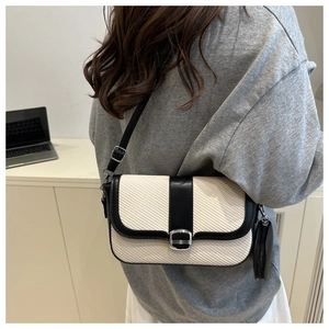 Detail of contrast stitch saddle bag with a detachable round coin purse and woven texture